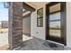Close-up showing a modern front door with stone columns and covered walkway at 20326 W Roma Ave, Buckeye, AZ 85396