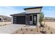 Charming home features a modern garage door, stone accents, and a drought-tolerant landscaped front yard at 20326 W Roma Ave, Buckeye, AZ 85396