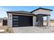 Well-maintained home with modern garage door, gray brick accents, and clean landscaping at 20326 W Roma Ave, Buckeye, AZ 85396
