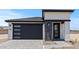 Stylish home exterior features a modern garage door, stone accents, and a welcoming entrance at 20326 W Roma Ave, Buckeye, AZ 85396