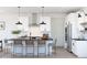 Modern kitchen with stainless steel appliances, white cabinets, and a spacious island with seating at 20326 W Roma Ave, Buckeye, AZ 85396