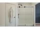 Modern walk-in shower with sleek sliding glass doors, white subway tile, and matte black fixtures at 20326 W Roma Ave, Buckeye, AZ 85396