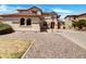 Tan two-story home with tile roof, rock yard, driveway, and basketball hoop at 21334 E Lords Ct, Queen Creek, AZ 85142