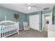 Cozy teal Bedroom featuring a white crib, chair, and closet with sliding doors at 21716 S 225Th Way, Queen Creek, AZ 85142