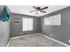 Bedroom featuring dark gray walls, a ceiling fan, television, and pegboard wall decoration at 21716 S 225Th Way, Queen Creek, AZ 85142