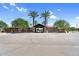 Community entrance showcasing mature palm trees and shade structures over the entrances at 21716 S 225Th Way, Queen Creek, AZ 85142