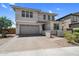 Two-story home with a large driveway and a gray garage door exhibits appealing exterior elevation at 21716 S 225Th Way, Queen Creek, AZ 85142