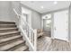 Inviting foyer with staircase, wood-look floors and a bench near the front door at 21716 S 225Th Way, Queen Creek, AZ 85142