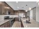 Modern kitchen with granite countertops, stainless steel appliances, and dark wood cabinets at 21716 S 225Th Way, Queen Creek, AZ 85142