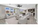 Bright living room with hardwood floors, a ceiling fan, and large windows at 21716 S 225Th Way, Queen Creek, AZ 85142