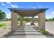 Community pergola with brick pillars casts shadows on a walkway through a beautifully landscaped public space at 21716 S 225Th Way, Queen Creek, AZ 85142
