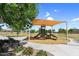 Community playground with slides and climbing structure is shaded by a large awning on a sunny day at 21716 S 225Th Way, Queen Creek, AZ 85142