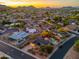 Scottsdale neighborhood aerial view featuring mountain views at sunset and a home with mature trees and desert landscaping at 2712 E Mountain View Rd, Phoenix, AZ 85028