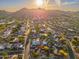 Beautiful Scottsdale neighborhood aerial view featuring mountain views at sunset and a home with mature trees at 2712 E Mountain View Rd, Phoenix, AZ 85028