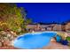 Serene backyard showcasing a refreshing pool, cascading waterfall, and a cozy outdoor dining area with desert landscaping at 2712 E Mountain View Rd, Phoenix, AZ 85028