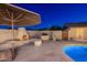 Cozy outdoor fireplace and grilling area complemented by desert landscaping, offering a perfect setting for outdoor entertaining at 2712 E Mountain View Rd, Phoenix, AZ 85028