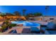 Inviting backyard oasis with a beautiful pool, rock waterfall, string lights, and cozy outdoor seating for relaxing evenings at 2712 E Mountain View Rd, Phoenix, AZ 85028