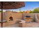 Cozy outdoor space featuring a fireplace, grill, and beautiful desert landscaping with mountain views in the background at 2712 E Mountain View Rd, Phoenix, AZ 85028