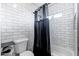Modern bathroom with white subway tile, a bathtub, and a dark shower curtain at 2712 E Mountain View Rd, Phoenix, AZ 85028