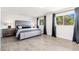 Serene bedroom with gray upholstered bed, tile floors, and ample natural light at 2712 E Mountain View Rd, Phoenix, AZ 85028