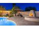 Backyard showcasing a shimmering pool, elegant outdoor dining and charming fireplace with ample space for outdoor entertainment at 2712 E Mountain View Rd, Phoenix, AZ 85028