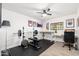Bright home gym features weightlifting equipment, a ceiling fan, and a desk with a view at 2712 E Mountain View Rd, Phoenix, AZ 85028