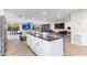 Kitchen island with bar seating, stainless steel appliances, and open view to the living room with large TV at 2712 E Mountain View Rd, Phoenix, AZ 85028
