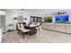 Open concept living room with modern decor, stylish dining table, and a large wall-mounted television at 2712 E Mountain View Rd, Phoenix, AZ 85028