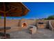 Charming outdoor fireplace with built-in seating and grill area, ideal for cozy evenings and al fresco dining at 2712 E Mountain View Rd, Phoenix, AZ 85028