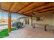 Covered patio with wooden beams, fan, and comfortable outdoor seating, creating a relaxing space with pool access at 2712 E Mountain View Rd, Phoenix, AZ 85028