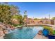Backyard pool with rock waterfall, outdoor seating, grill, and desert landscaping at 2712 E Mountain View Rd, Phoenix, AZ 85028