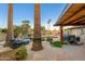 Backyard pool area with a waterfall feature, wood-burning fireplace, seating, and mature trees at 2712 E Mountain View Rd, Phoenix, AZ 85028