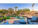 Backyard pool with waterfall feature, desert landscaping, and shade trees at 2712 E Mountain View Rd, Phoenix, AZ 85028
