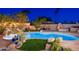 Beautiful backyard oasis featuring a sparkling pool, lush landscaping, and an inviting outdoor living space with fireplace at 2712 E Mountain View Rd, Phoenix, AZ 85028