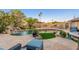 Backyard pool with rock waterfall, lush landscaping, outdoor seating, and built-in grill at 2712 E Mountain View Rd, Phoenix, AZ 85028