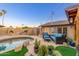 Backyard pool with outdoor fireplace, grill, patio seating, and lush plants at 2712 E Mountain View Rd, Phoenix, AZ 85028