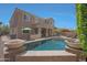 View of the backyard pool area with rock features, house exterior, patio, and lounge chairs at 2784 E Honeysuckle Pl, Chandler, AZ 85286