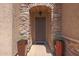 Covered front door with stone archway, hanging light, and terracotta planters at 2784 E Honeysuckle Pl, Chandler, AZ 85286