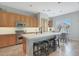Well-equipped kitchen with an island, wooden cabinets, stainless steel appliances, and bar stool seating at 2784 E Honeysuckle Pl, Chandler, AZ 85286