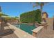 Swimming pool with waterfall feature, surrounded by shrubbery, umbrellas, and patio seating at 2784 E Honeysuckle Pl, Chandler, AZ 85286