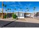 Charming single-story home with covered parking, desert landscaping, and palm trees at 303 S Recker Rd # 141, Mesa, AZ 85206