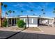 Charming single-story home with covered parking, desert landscaping, and palm trees at 303 S Recker Rd # 141, Mesa, AZ 85206