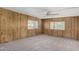 Inviting living room with cozy carpeting, wood-paneled walls, a ceiling fan, and bright windows at 303 S Recker Rd # 141, Mesa, AZ 85206