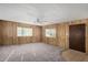 Inviting living room with cozy carpeting, wood-paneled walls, a ceiling fan, and bright windows at 303 S Recker Rd # 141, Mesa, AZ 85206
