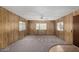 Inviting living room with cozy carpeting, wood-paneled walls, a ceiling fan, and bright windows at 303 S Recker Rd # 141, Mesa, AZ 85206