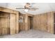 Spacious bedroom featuring wood paneling, ceiling fan, and closet with sliding doors at 303 S Recker Rd # 141, Mesa, AZ 85206