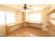 Bedroom with a ceiling fan, two windows providing natural light, built-in desk and shelves, and tile flooring at 36655 N 25Th St, Cave Creek, AZ 85331