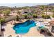 Aerial view of a serene backyard pool area with lounge chairs, outdoor bar, and desert landscape at 3723 S Pottery Rd, Gold Canyon, AZ 85118
