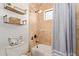 Cozy bathroom with travertine-tiled shower and tub, decorative shelves, and practical toilet paper storage at 3723 S Pottery Rd, Gold Canyon, AZ 85118