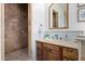 Bathroom with a wooden vanity, stone sink, and decorative mirror next to a large walk-in shower at 3723 S Pottery Rd, Gold Canyon, AZ 85118